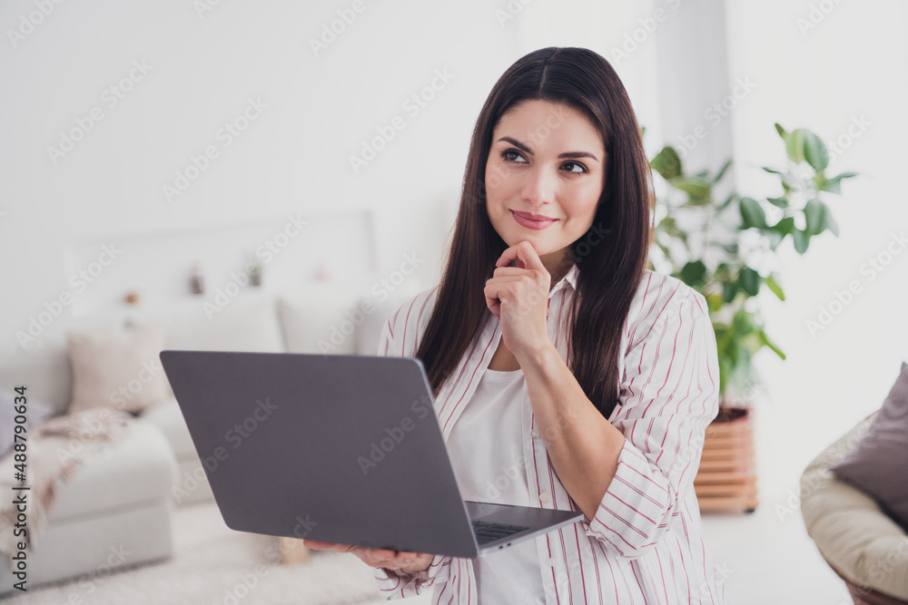 Portrait of attractive minded focused long-haired woman using laptop analyzing data web project at home indoors Portrait of attractive minded focused long-haired woman using laptop analyzing data web project at home indoors