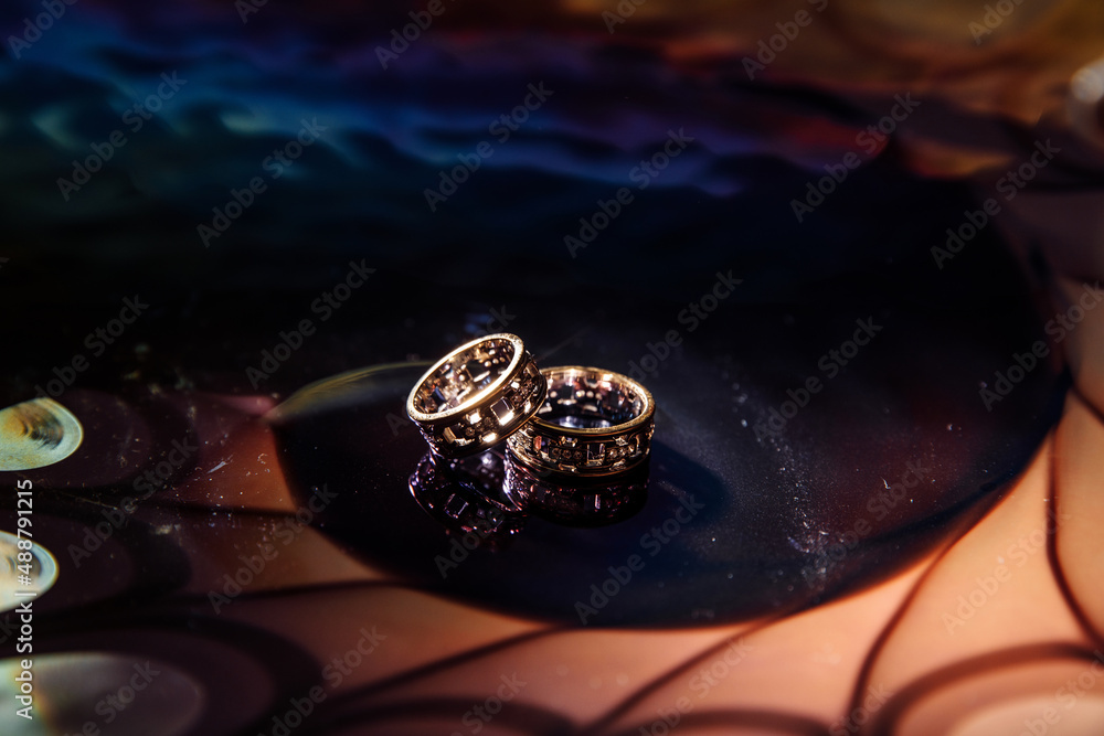 Wedding rings on the table. Wedding details for the ceremony. Wedding accessories. Close-up. Wedding rings on the table. Wedding details for the ceremony. Wedding accessories. Close-up.