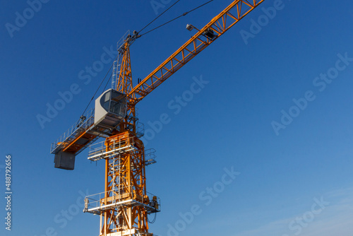 Tower crane against the blue sky. Tower crane operator's cabin. Crane operator at work.