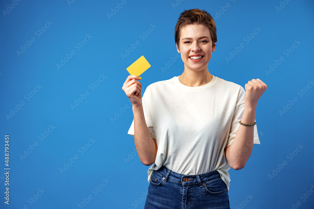 Image of young woman holding business card with copy space on blue background
