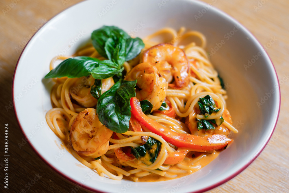 Pasta with shrimps garnished with basil. Seafood dish.