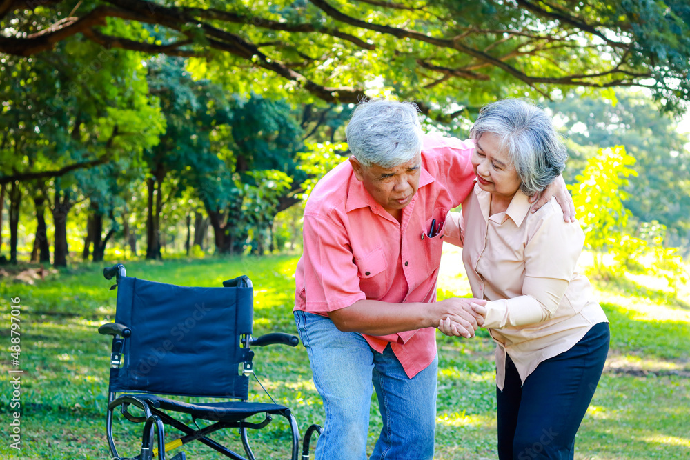 an elderly man in a wheelchair relaxing in the garden He tried to get up and walked, he had severe knee pain. His wife takes care of him. The concept of caring for osteoarthritis patients. an elderly man in a wheelchair relaxing in the garden He tried to get up and walked, he had severe knee pain. His wife takes care of him. The concept of caring for osteoarthritis patients.