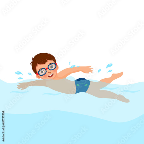 cute little boy wear googles enjoying swimming in a pool