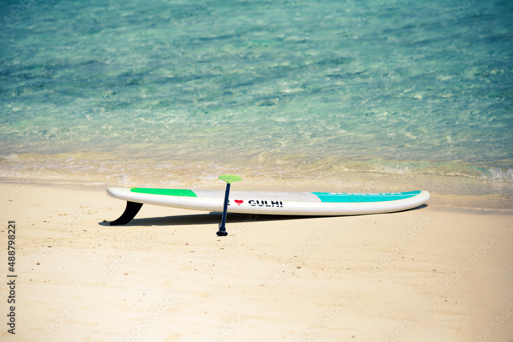 Sup Board on sandy beach in Maldives with writing Sup Board on sandy beach in Maldives with writing