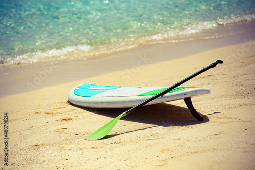 Sup Board on sandy beach in Maldives with writing 