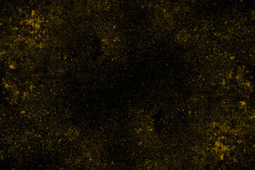 Scattered spread yellow dust particles on black background