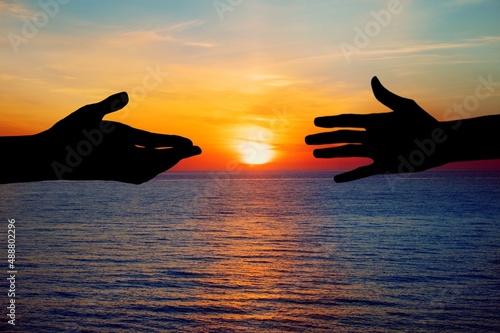 Human hand Asking help Concept. hands helping each other on Sunset background.