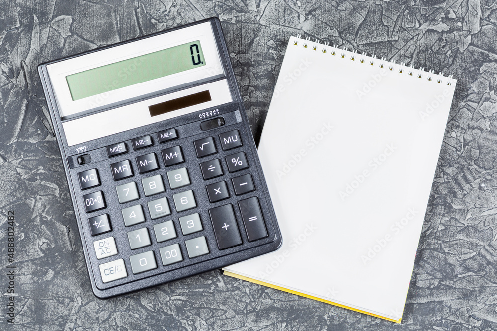 Business concept, finance, accounting. Modern black calculator and notepad (notebook) on a black (dark) background. Space for text. Business concept, finance, accounting. Modern black calculator and notepad (notebook) on a black (dark) background. Space for text.