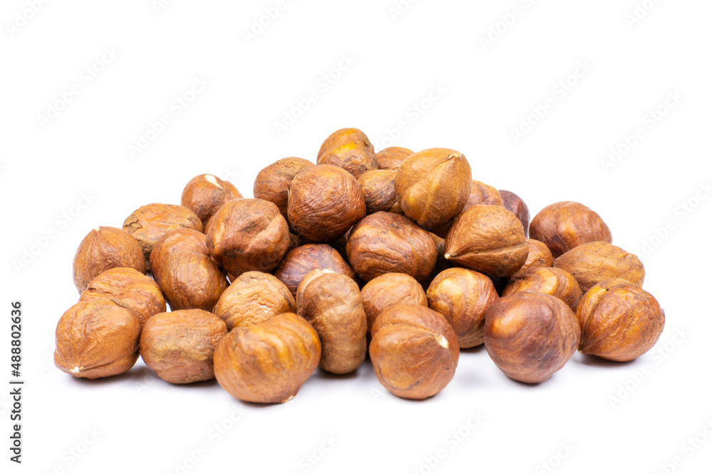Peeled hazelnuts on a white isolated background. A handful of nuts in close-up. Template for the design. Peeled hazelnuts on a white isolated background. A handful of nuts in close-up. Template for the design.