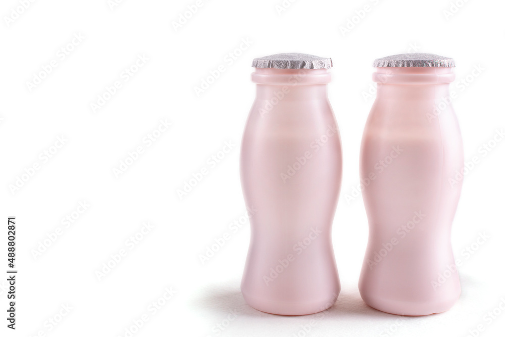Two bottles of milk yogurt (kefir), on a white isolated background. The concept of probiotics (bifidobacteria) and healthy nutrition. Packaging of fermented milk products.