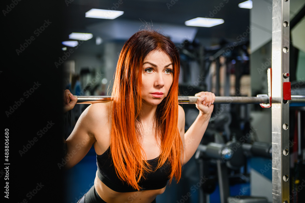 Sportive fit strong woman exercise with lifting weights, hold heavy dumbbells at modern gym interior, healthy lifestyle