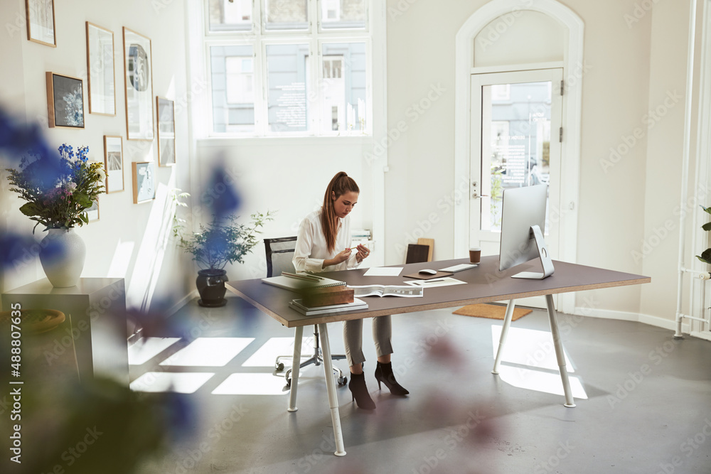 Young female architect working on designs at her desk Young female architect working on designs at her desk