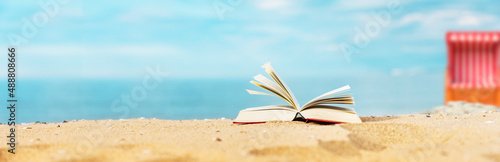 Buch am Strand mit Meer im Hintergrund