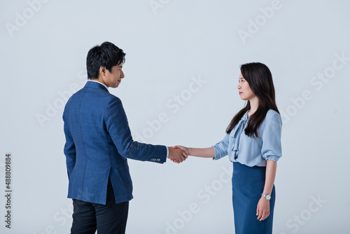 ビジネスシーンで握手をする男女