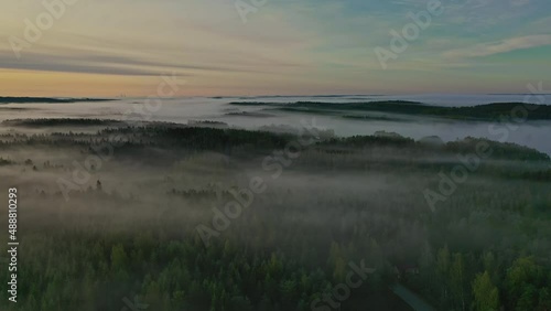 Aerial footage video of foggy summer morning. Flying over forest and lake. 