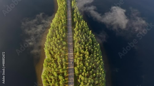 Aerial view of the road between the islands of blue lake Paijanne. Blue lake, islands and green forest from above on a sunny summer evening. Lake landscape in Finland