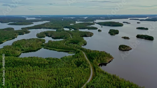 Aerial view of of small islands on a blue lake Saimaa. Landscape with drone. Blue lakes, islands and green forests from above on a cloudy summer morning. Lake landscape in Finland.	