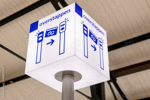 Zutphen, The Netherlands - February 20, 2022: Square sign informing the location of transference of one train company to another on a station platform. TRANSLATION: TRANSFER.