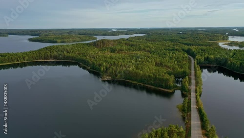 Aerial view of of small islands on a blue lake Saimaa. Landscape with drone. Blue lakes, islands and green forests from above on a cloudy summer morning. Lake landscape in Finland.	