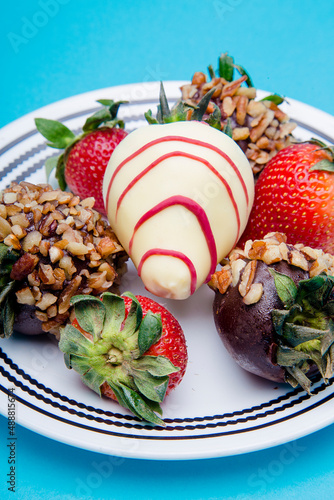 Strawberries with chocolate and nuts on a blue background