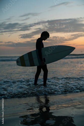 朝の海でサーフィンをする男性