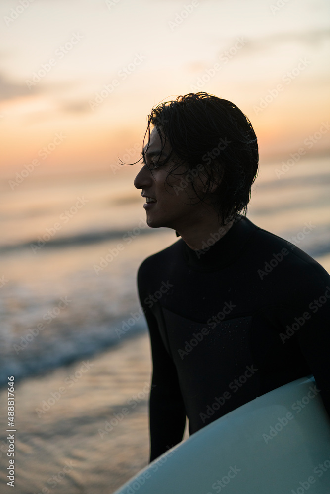 Fototapeta premium 朝の海でサーフィンをする男性