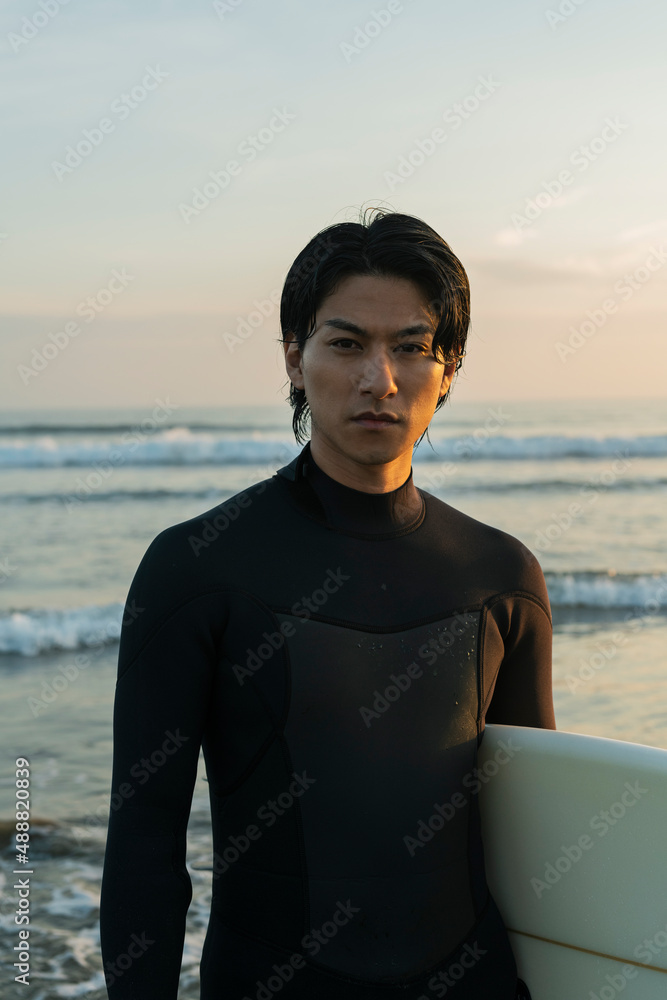 Fototapeta premium 朝の海でサーフィンをする男性