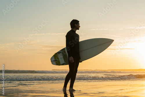 朝の海でサーフィンをする男性