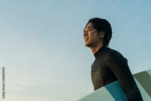 Photography 朝の海でサーフィンをする男性