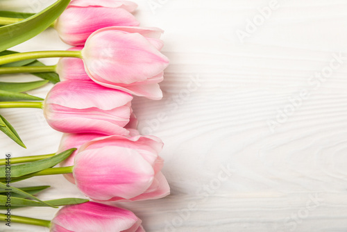Fototapeta Naklejka Na Ścianę i Meble -  Pink tulips on a white wooden background.Top view. Spring bouquet.Holiday concept.Women's day, Valentine's day,Easter, birthday.Copy space.
