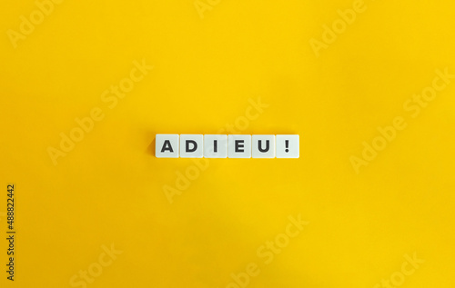 Adieu Exclamation on Letter Tiles on Yellow Background. Minimal Aesthetics.