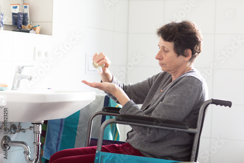 Ältere Frau im Rollstuhl in einem Badezimmer
