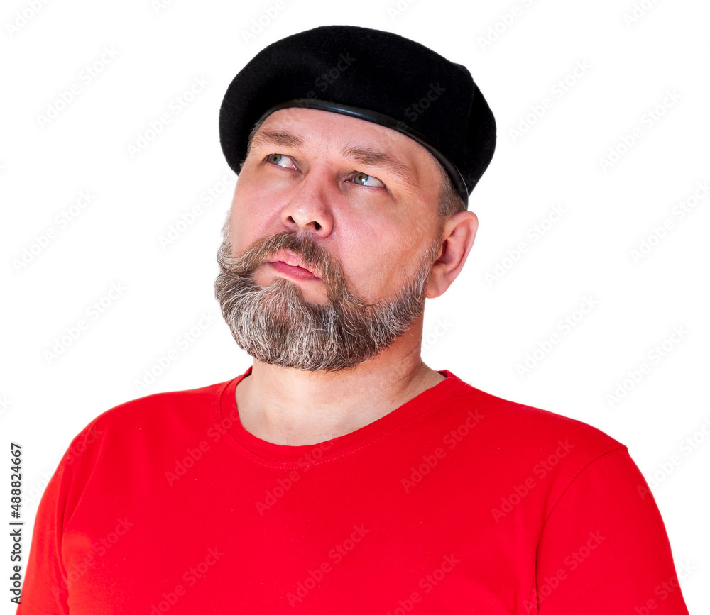 A middle-aged man with a gray beard in a red t-shirt and black beret, isolated on white. The man looked up thoughtfully. A middle-aged man with a gray beard in a red t-shirt and black beret, isolated on white. The man looked up thoughtfully.