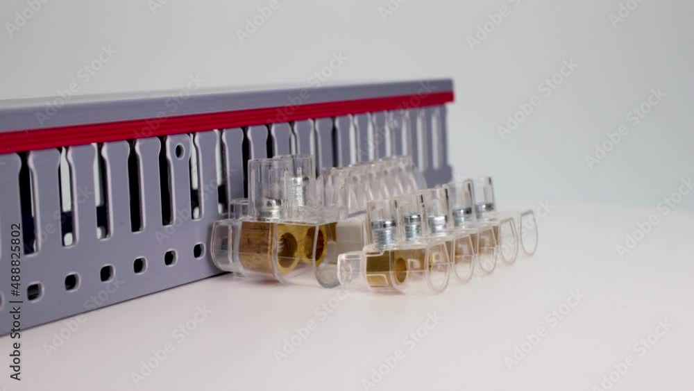 Electrical terminal blocks and distribution blocks on a white background. Connecting electrical cables of different voltages. Channel for laying electrical cables. Electrician. Close-up. Electrical terminal blocks and distribution blocks on a white background. Connecting electrical cables of different voltages. Channel for laying electrical cables. Electrician. Close-up.