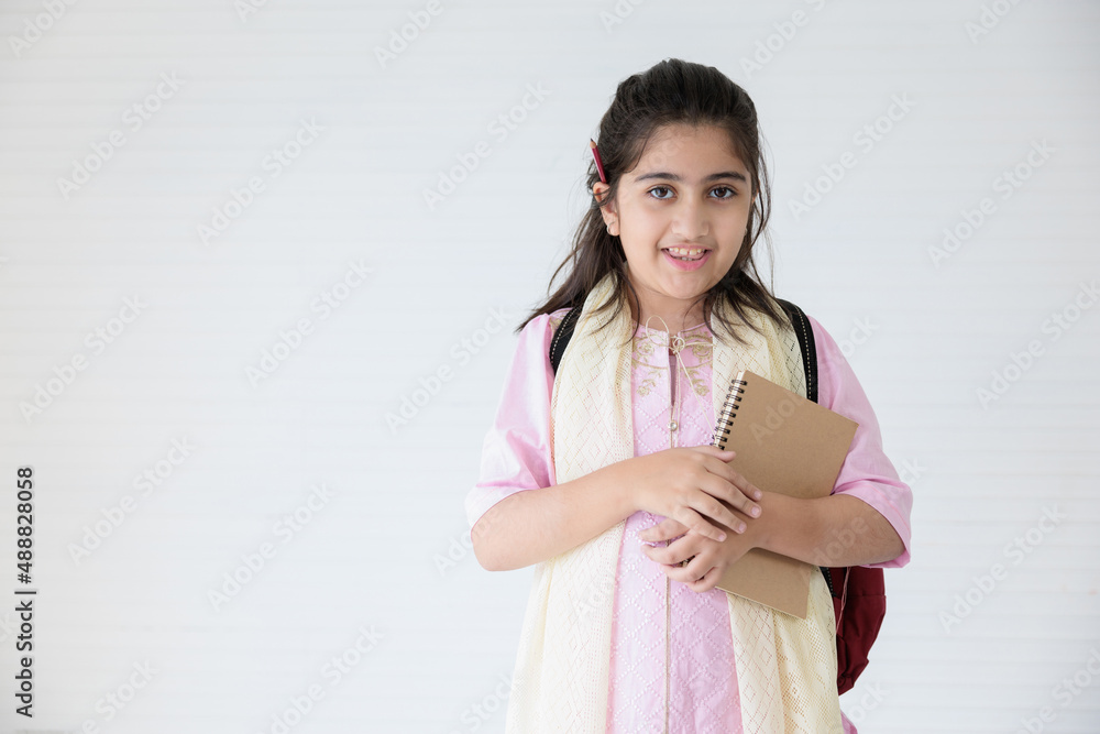 cute indian girl smiling and holding notebook for learning, education concept cute indian girl smiling and holding notebook for learning, education concept