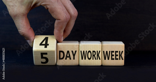 4 or 5 day work week symbol. Businessman turns cubes and changes words 5 day work week to 4 day work week. Beautiful grey background. Copy space. Business and 4 or 5 day work week concept. photo