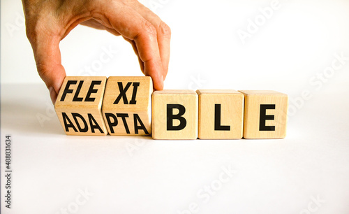 Adaptable or flexible symbol. Businessman turns wooden cubes and changes the word Adaptable to Flexible. Beautiful white table white background, copy space. Business, adaptable or flexible concept.