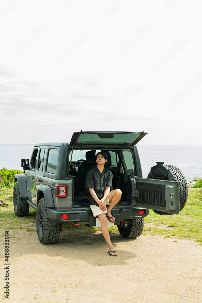 Fototapeta premium 車のトランクに座る男性