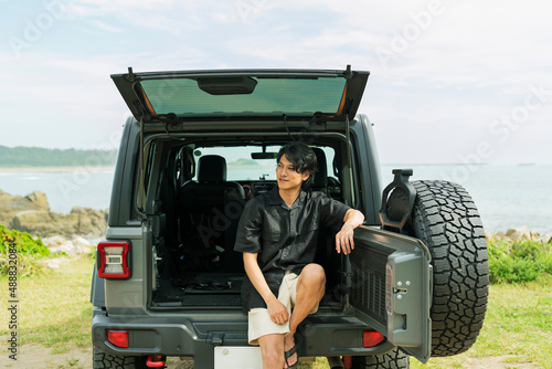 車のトランクに座る男性 photo