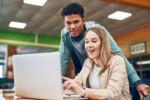 Heres all the information at out fingertips. Shot of a young man looking on while a female student works on a laptop.