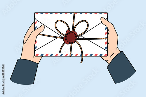 Post service and letter concept. Postman hands holding letter for person with official post stamp in envelope vector illustration 