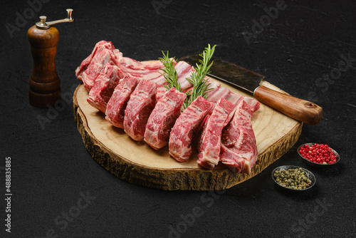 Raw lamb rib roast on wooden slab