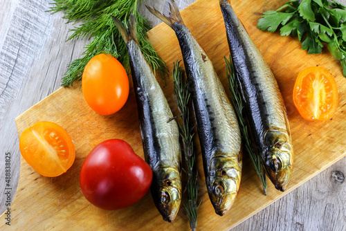 smoked fish and vegetables on wooden cutting board