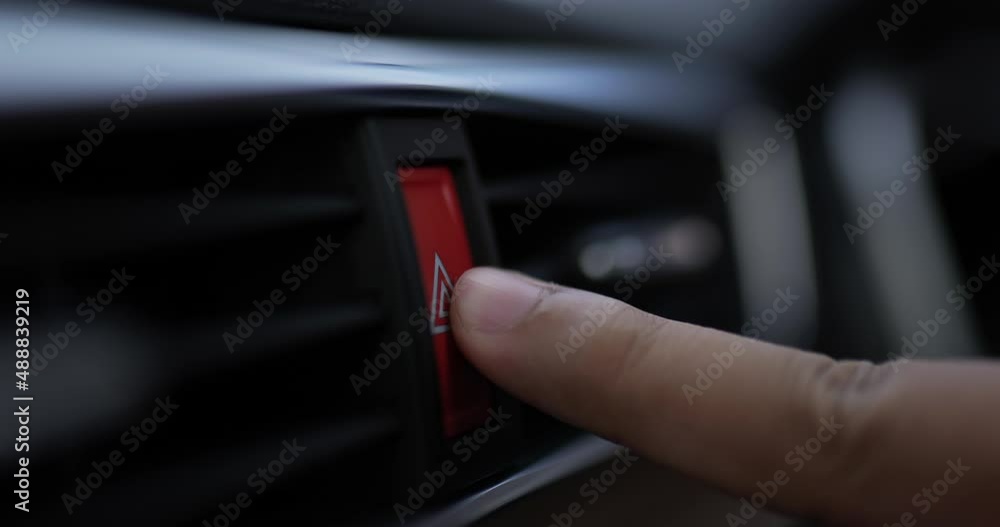 Close up of Man pressing car hazard emergency lights button in car motor. Car warning lights after breakdown accident. Car service concept. Close up of Man pressing car hazard emergency lights button in car motor. Car warning lights after breakdown accident. Car service concept.