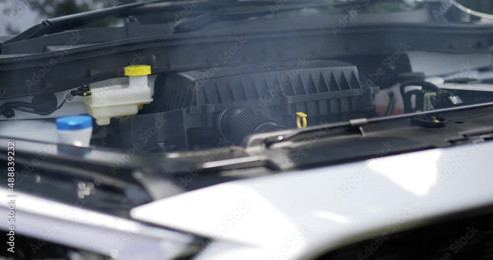 Close up side view of Car engine is starting to smoke and burn. Man open the hood. Car service concept. Close up side view of Car engine is starting to smoke and burn. Man open the hood. Car service concept.