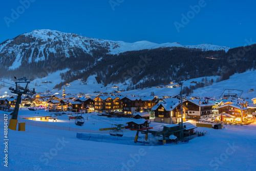 Fototapeta Naklejka Na Ścianę i Meble -  View of Italian village Livigno during twilight. Ski resort in winter time with snowcapped mountains and ski slopes in background