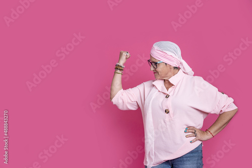Cheerful sick woman showing bicep for positive attitude photo