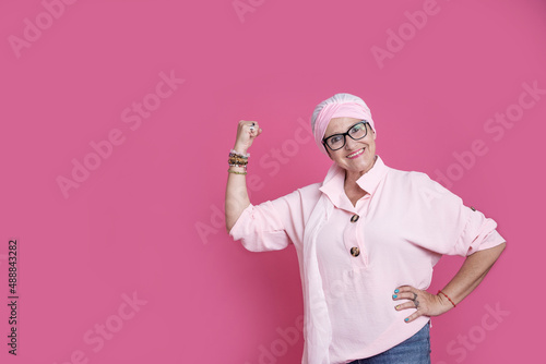 Cheerful sick woman showing bicep for positive attitude photo