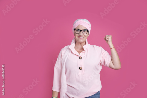 Cheerful sick woman showing bicep for positive attitude
