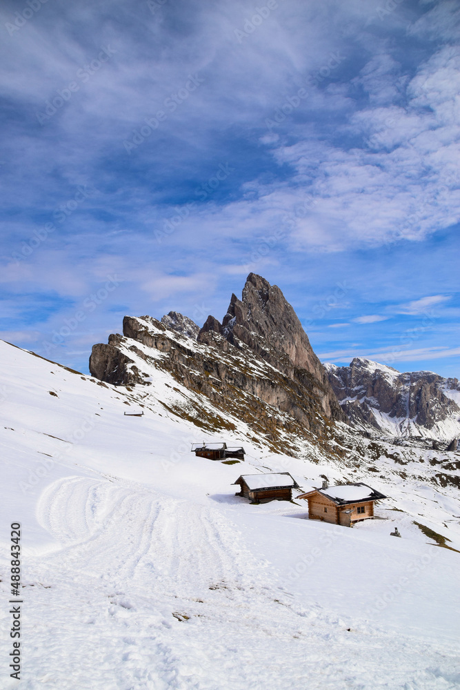 Snowy Seceda mountain in the italian Dolomites in front of cottages